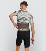 Rear view showcasing the Mono Tie Dye Off Grid Men's Gravel Cycling Jersey's three reinforced back pockets and additional secure zipper pocket for essential gear.