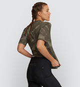 Side view of a cyclist in the Khaki Dye Off Grid Gravel Tech LS Tee, emphasizing the garment's versatility and robust flat-lock seams for durability on any terrain.