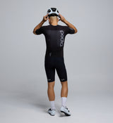 Back profile of the Men's Pro Pursuit Crit Suit – Black, showing sculpted sleeve panels with AeroPRISMA fabric, silicone leg grippers, and ergonomic design for high-speed movement.