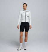 Front view of a female cyclist wearing the Porcelain Deflect 2.0 Jacket, featuring a high-performance fit, chest pocket with waterproof zipper, and clean, aerodynamic styling.