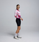 Side profile of the AirFoils Hot Pink long sleeve cycling jersey, worn by a female cyclist, emphasizing underarm mesh paneling for breathability and sleek, aerodynamic contours.