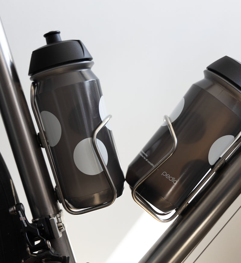 Pedla bidon securely mounted in bike bottle cage; compact, accessible, and perfect for hydration on the move