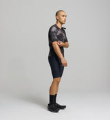 Side profile of dark purple men’s cycling jersey – ergonomic sleeve design and hydration tube channel for long-distance cycling support