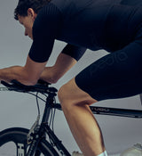 Studio close-up of Pro Men's SuperFit Air Bib Shorts in Black, showcasing the iridescent reflective accents and premium stretch-woven fabric, designed for enhanced visibility, breathability, and all-day comfort during intense cycling rides.