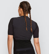 Back view of Pro Women's Velocity Cycling Jersey in Black on model, featuring a breathable mesh back panel, reinforced rear pockets, and elasticated openings for secure storage and improved airflow during long rides.