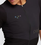 Close-up view of Pro Women's Velocity Cycling Jersey in Black on model, detailing the aerodynamic stretch-woven fabric, flatlock seams for chafe-free comfort, and YKK zipper for easy adjustments during cycling.